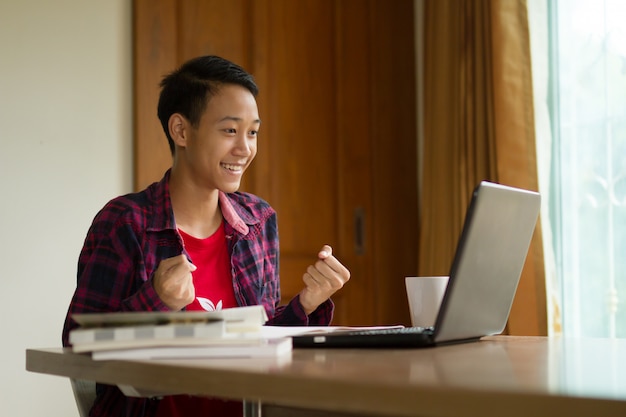 Asian boy exciting in front of the laptop