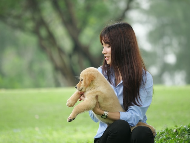 アジアの男の子と女の子、公園でwiyh子犬を遊ぶ