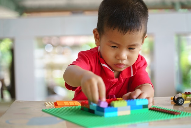 Asian boy is playing building blocks