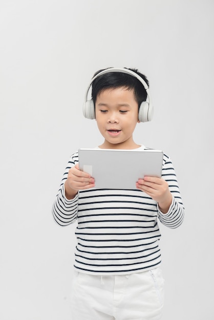 Asian boy laying tablet computer with headset