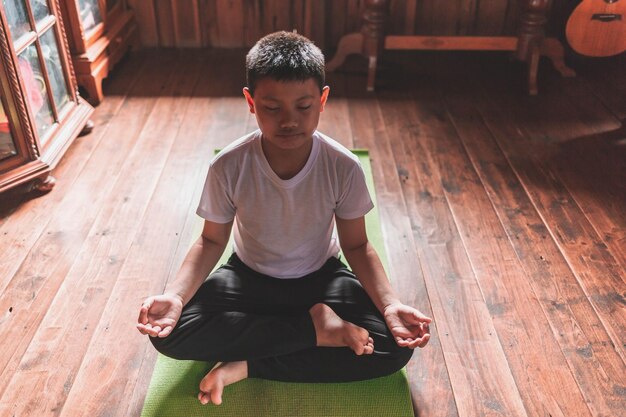 Asian boy meditating alone at home peacefullyv