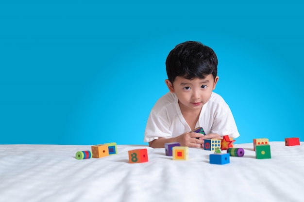 Asian boy play square block puzzle at home on the bed