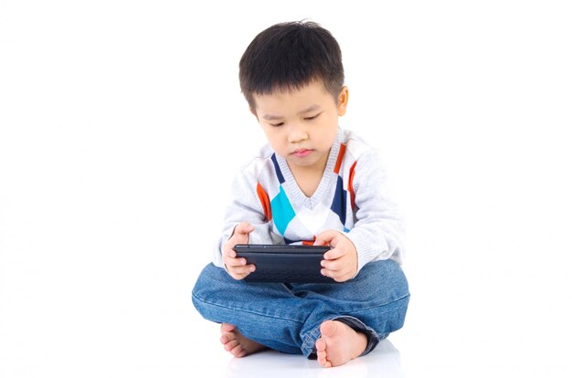 アジアの少年がデジタルタブレットでゲームをプレイ