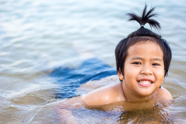 asian boy playing on the sea.