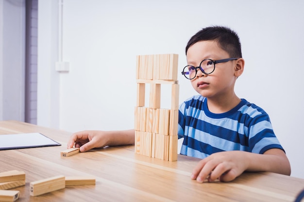 Asian boy playing with a wooden puzzle