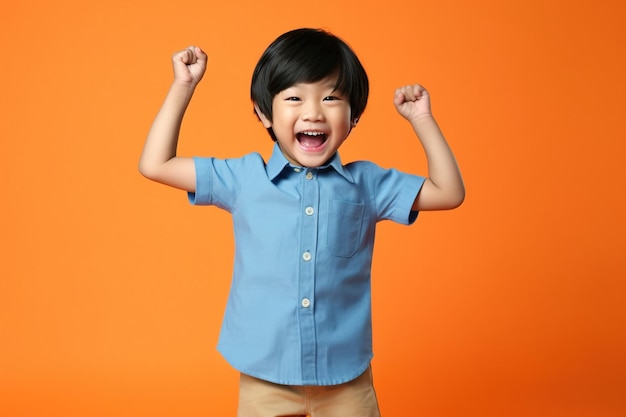 Asian boy raises hands up having fun on studio background happy kid portrait