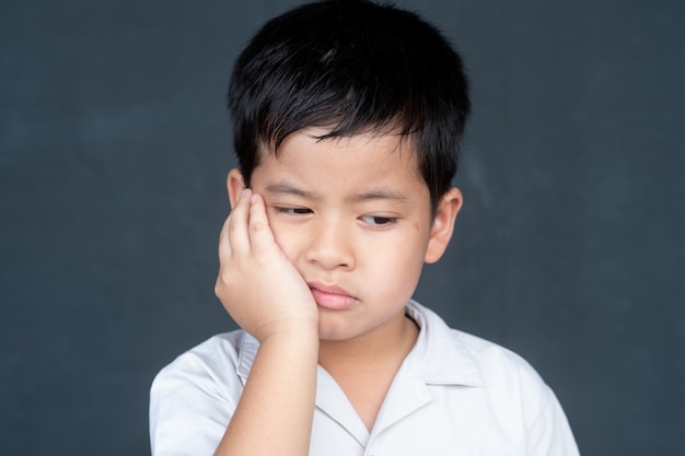 Asian boy showing frustration and angry, isolated on black background.