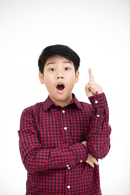 Asian boy smiling and pointing finger up .