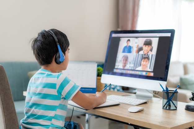 Asian boy student video conference e-learning with teacher and classmates on computer