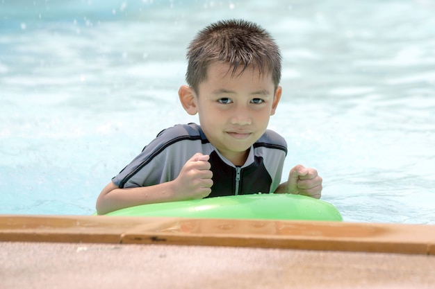 水着姿のアジアの少年、プールで水泳を楽しんでいます。