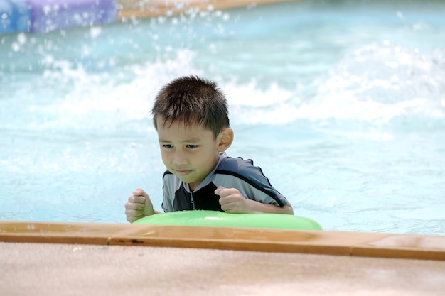 水着姿のアジアの少年、プールで水泳を楽しんでいます。