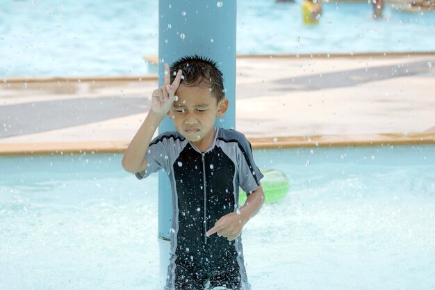 水着姿のアジアの少年、プールで水泳を楽しんでいます。