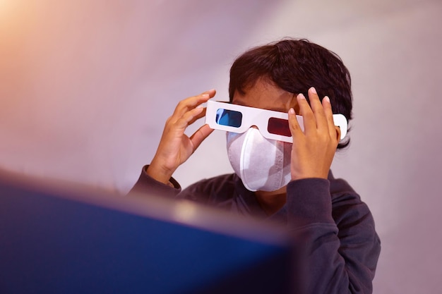 Asian boy uses 3D glasses to watch 3D movies that support 3D glasses