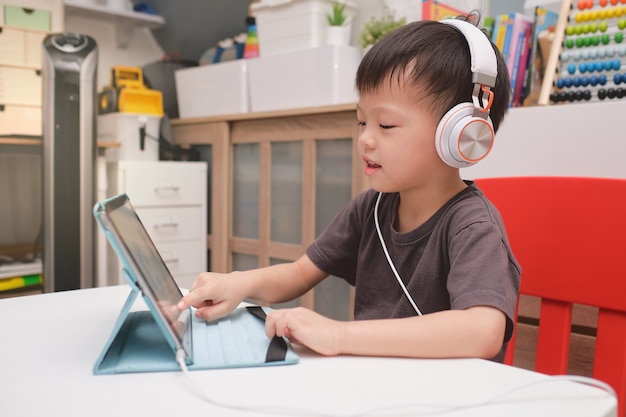 Asian boy using tablet at home