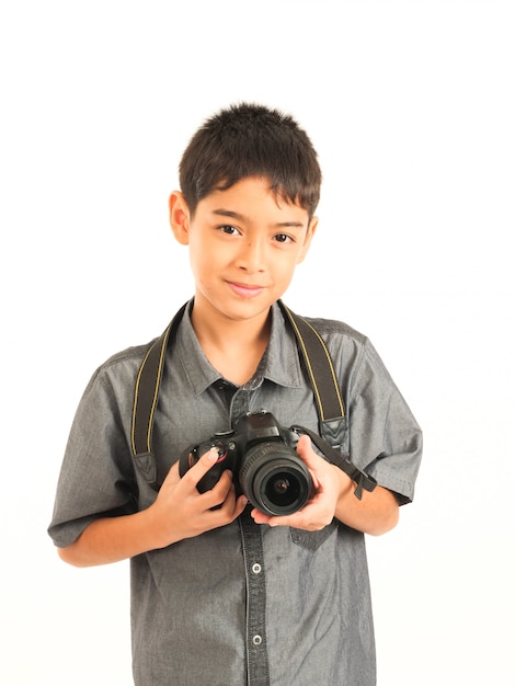 Ragazzo asiatico con la macchina fotografica di dslr su fondo bianco