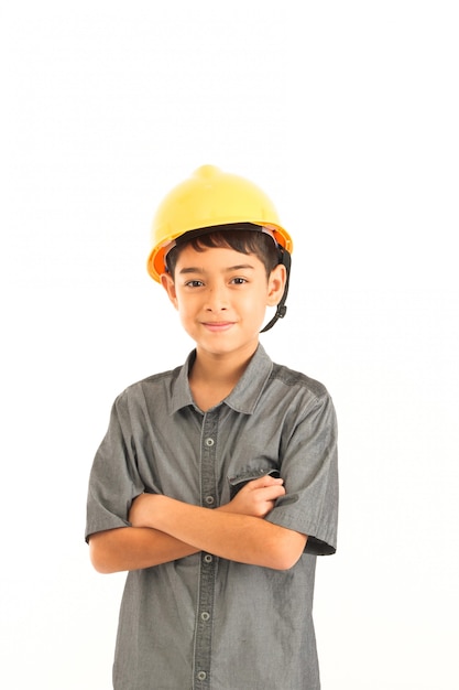 白い背景の上のエンジニアと安全性の黄色い帽子を持つアジアの少年