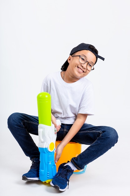 Asian boy with squirt gun on white background