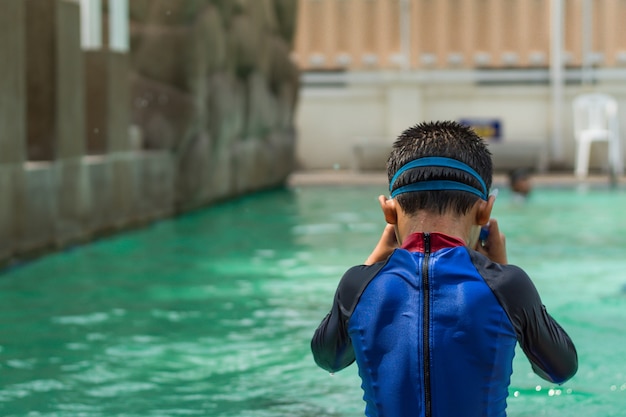 アジアの少年たちがプールで泳いでいます。