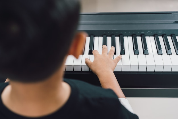 Photo an asian boys  playing the piano.