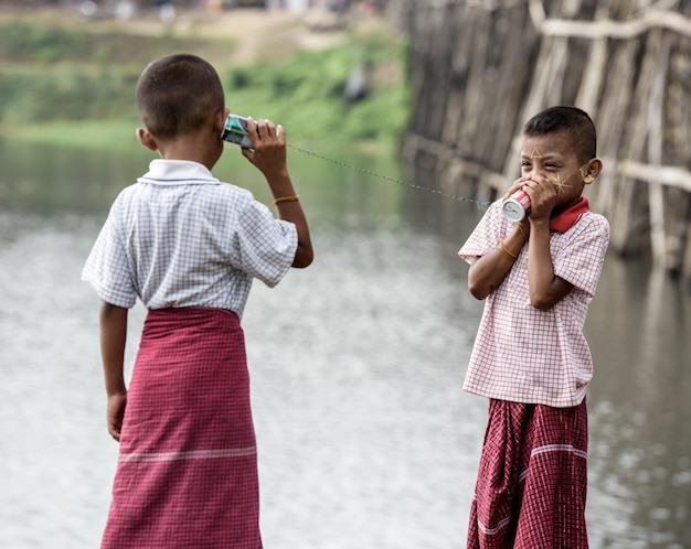 Asian boys talking on a can phone