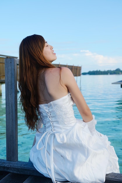 asian  bride with a veil on the beach in the sky and blue sea. honeymoon on the fantastic island at summer