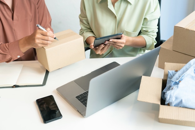 Asian business couple owner working at home with packing box of their online store prepare to deliver products to customers, alpha generation lifestyle concept
.