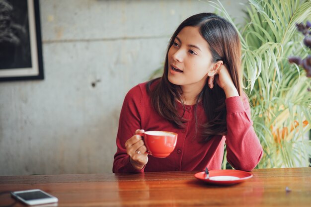 Asian business girl working and drinking coffee in cafe with laptop 