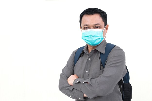 Asian business male wears grey shirt and medical face mask to protect his respiratory system from COVID-19 (Coronavirus-19) or pathogen in healthcare lifestyle.