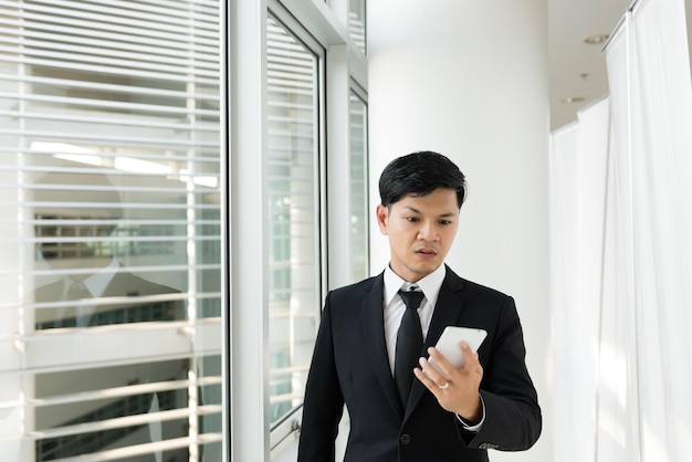 Asian business man looking message telephone with ceo company about work