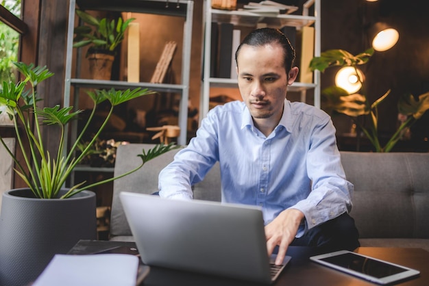 Uomo d'affari asiatico uomo d'affari freelance che lavora nello spazio di coworking o in un bar