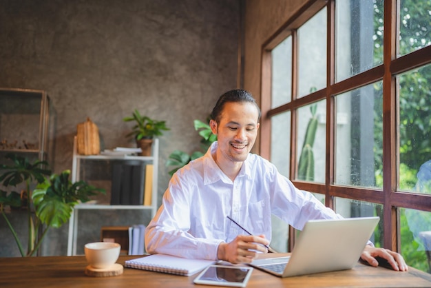 Uomo d'affari asiatico uomo d'affari freelance che lavora nello spazio di coworking o in un bar