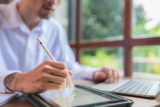 Uomo d'affari asiatico uomo d'affari freelance che lavora nello spazio di coworking o in un bar