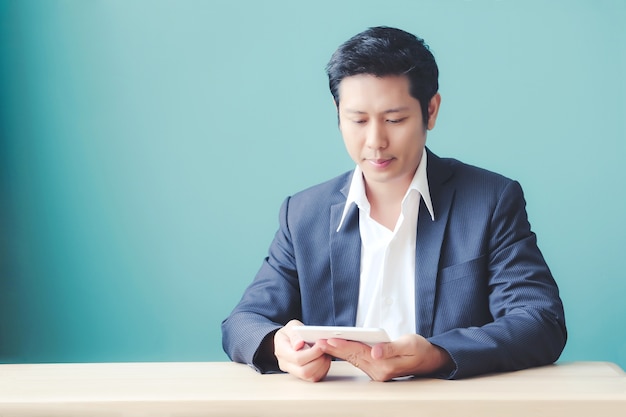 Asian business man using digital tablet while sitting at office table, business and technology