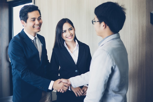 Asian Business people shaking hands agreement to sign contract and finishing up a meeting