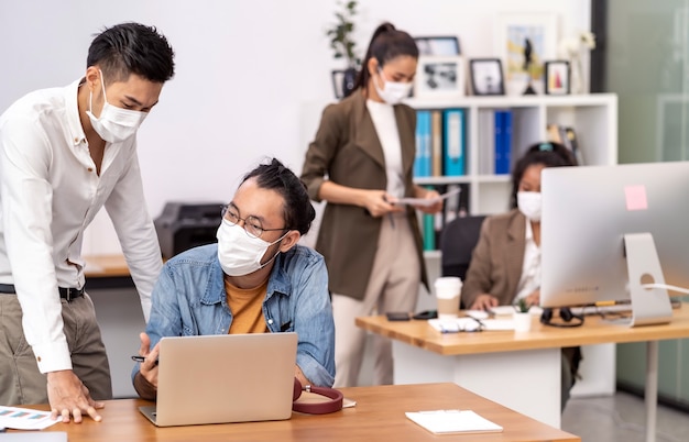 Asian business persons working in office wearing protective face mask