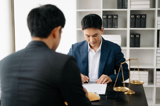 Photo asian business team and lawyers discussing contract papers sitting at the table concepts of law advice legal services at office