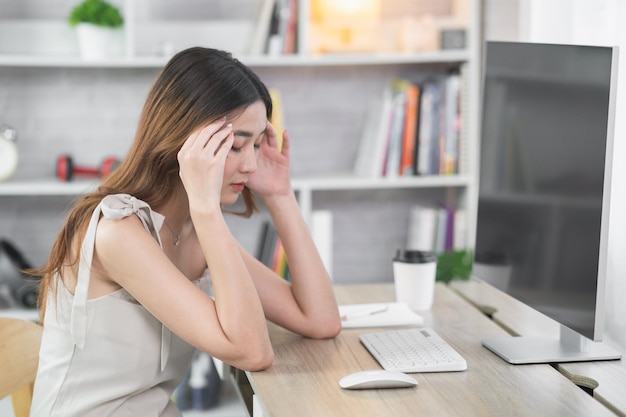 Donna d'affari asiatica che ha depressione stressante tempo triste lavorando su laptop o computer su tavolo di legno a casa ufficio depressione uomo triste serios lavorando da qualsiasi luogo