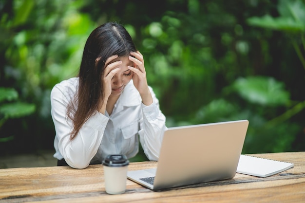 Asian business woman having stressful depression sad time working on laptop on wood table Depression man sad serios working from anywhere