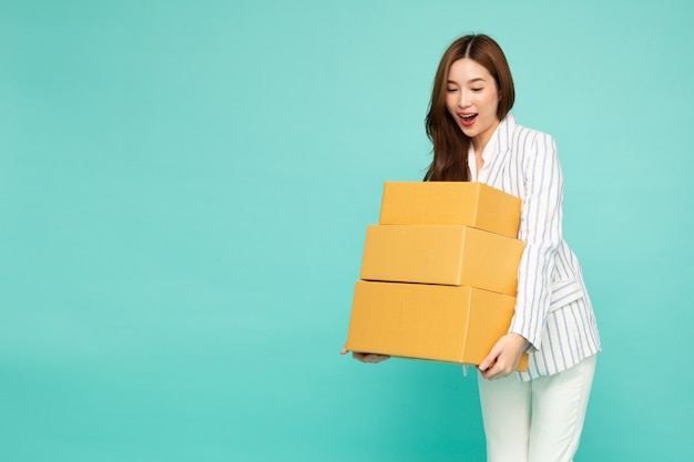 緑の背景で隔離のパッケージ小包ボックスを保持しているアジアのビジネス女性