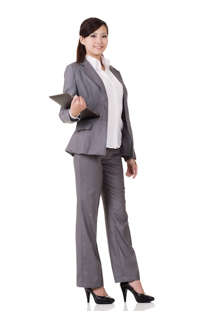 Asian business woman holding pad, full length portrait on white background.