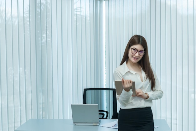 Asian business woman holding tablet in the officeWorking in the workplaceThailand people