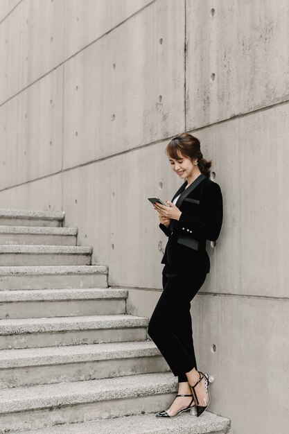 Asian business woman is chatting and standing on stair