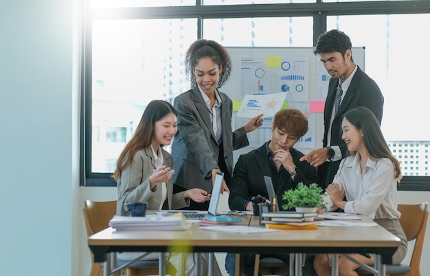 Asian business woman leader in a meeting with her multiethnic colleagues at the office presenting sales data or forecast for a project