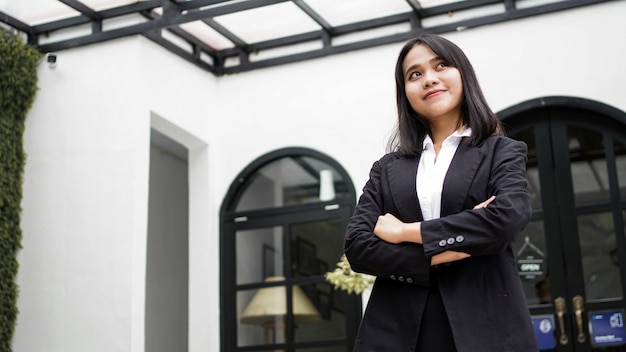 Asian business woman smiling and standing in front office