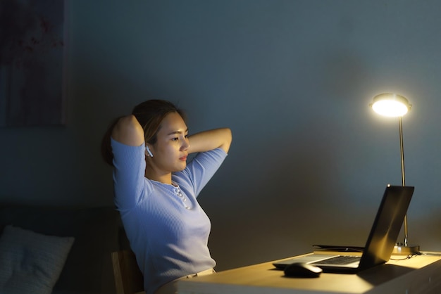 Asian business woman stress out with project business plan on computer laptop or notebook at home office at night Asian people occupational burnout syndrome concept