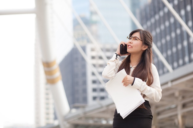 Asian business woman talking smart phone.