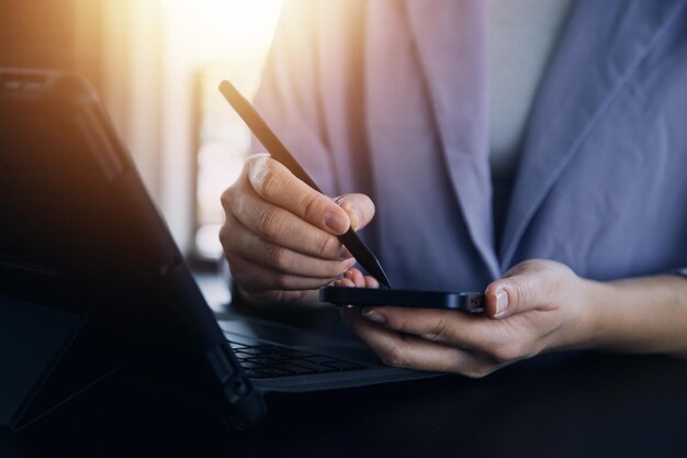 Asian Business woman using calculator and laptop for doing math finance on an office desk tax report accounting statistics and analytical research concept