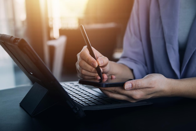 Asian Business woman using calculator and laptop for doing math finance on an office desk tax report accounting statistics and analytical research concept