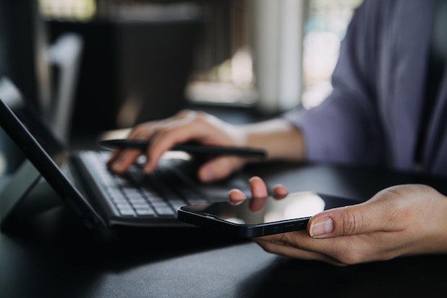 Asian Business woman using calculator and laptop for doing math finance on an office desk tax report accounting statistics and analytical research concept