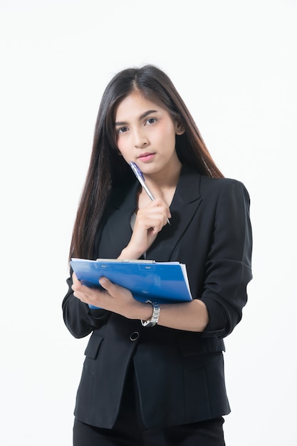 Le donne asiatiche di affari stanno sorridendo e tenendo con la lavagna per appunti per lavorare felice